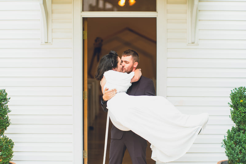Newlyweds kissing outside a small chapel